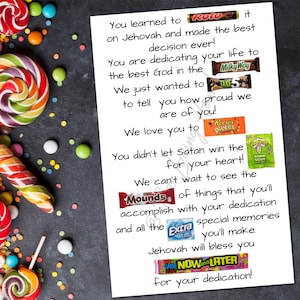May include: A white printed card with colorful candy and lollipops. The card has text and candy bar images. The text reads, "You learned to...on Jehovah and made the best decision ever!" and more. Colorful candies and lollipops surround the card.