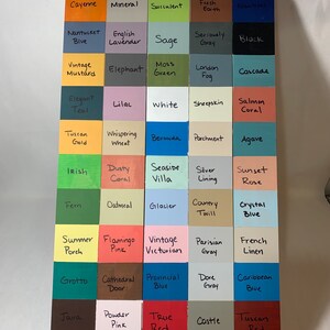 May include: A wooden color chart featuring a grid of painted squares, each labeled with a unique color name. Colors range from Imperial red to Willow Mist, showcasing a variety of hues for design inspiration. The chart is displayed on a white surface.