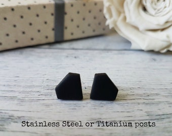 May include: A pair of black geometric stud earrings with a diamond shape. The earrings are made of polymer clay and have stainless steel or titanium posts.