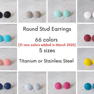 May include: A selection of round stud earrings in various colors, including black, gray, turquoise, white, maroon, pink, yellow, blue, gray with white flecks, and pink. The text "Round Stud Earrings" is displayed above the earrings, followed by "66 colors (21 new colors added in March 2020)" and "5 sizes". The text "Titanium or Stainless Steel" is displayed below the earrings.