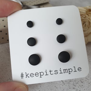 May include: A set of six black stud earrings displayed on a white card with the text "#keepitsimple".