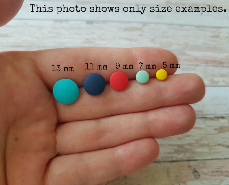 May include: Five round, colorful polymer clay earrings in different sizes. The earrings are 13 mm, 11 mm, 9 mm, 7 mm, and 5 mm in diameter.
