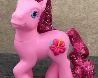 May include: Pink My Little Pony toy with a pink and yellow hibiscus flower on its side. The pony has a pink mane and tail with iridescent glitter.