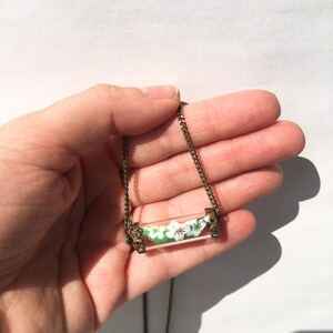 Collana con barchetta origami dentro a una bottiglietta messaggi.