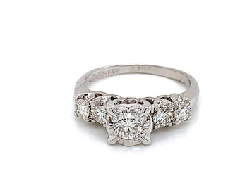 May include: A silver ring with a large, round, center diamond and smaller diamonds on either side of the center stone.