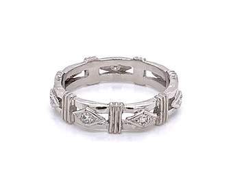 May include: A silver band ring with a delicate design featuring small diamonds set in a geometric pattern.