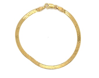 Pode incluir: Um bracelete de corrente de cobra plana dourado.