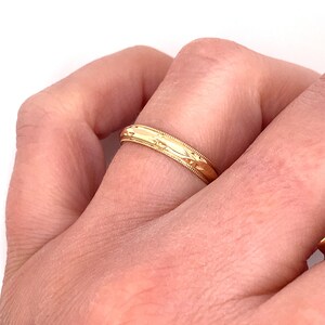 May include: A gold wedding band with a textured design.