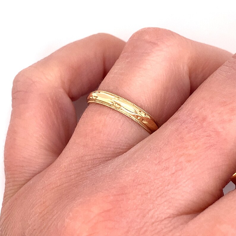 May include: A gold wedding band with a textured design.