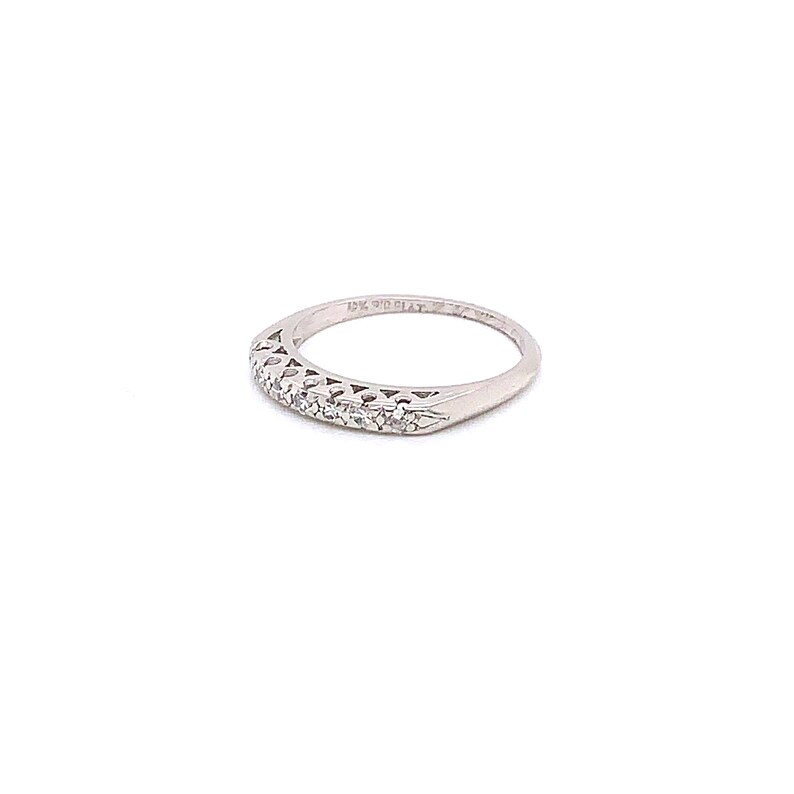 May include: A silver band ring with a row of small diamonds set in a delicate design. The ring is marked "14K Gold" on the inside.