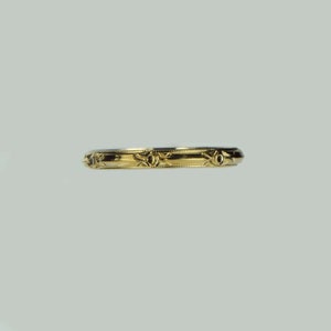 Könnte beinhalten: Ein Goldring mit einem dekorativen Design aus kleinen Sternen und Linien.