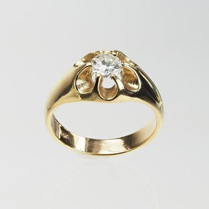 May include: A gold ring with a single round diamond set in a flower-shaped design. The ring is marked "14K" on the inside.
