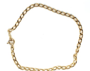 Puede incluir: Un brazalete de cadena dorada con cierre de langosta. La cadena está hecha de un diseño de eslabón curb.
