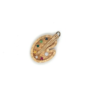 Puede incluir: Encanto de paleta de artista dorado con un pincel y piedras preciosas de colores.