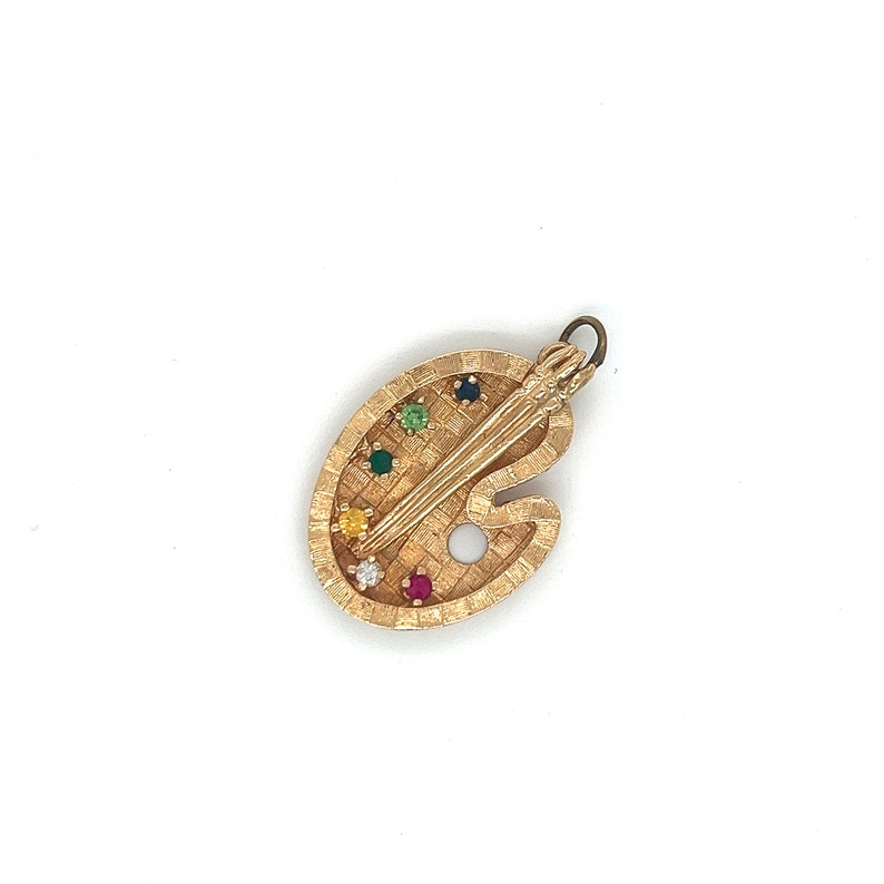 Puede incluir: Encanto de paleta de artista dorado con un pincel y piedras preciosas de colores.
