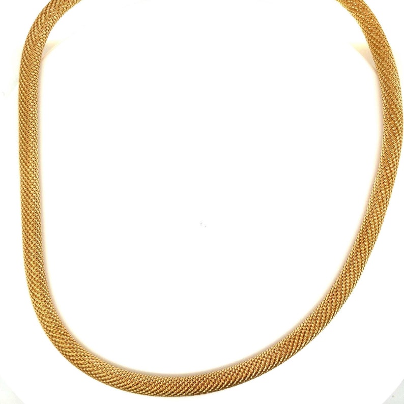May include: A gold chain necklace with a woven design.