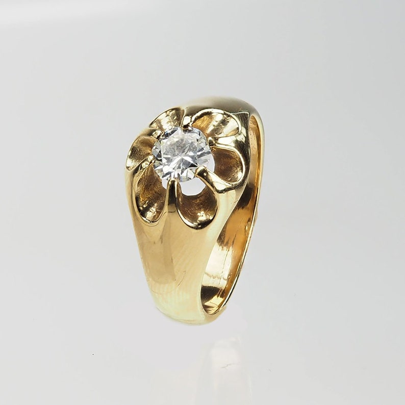 May include: A gold ring featuring a large, clear, round gemstone set in a flower-shaped design.