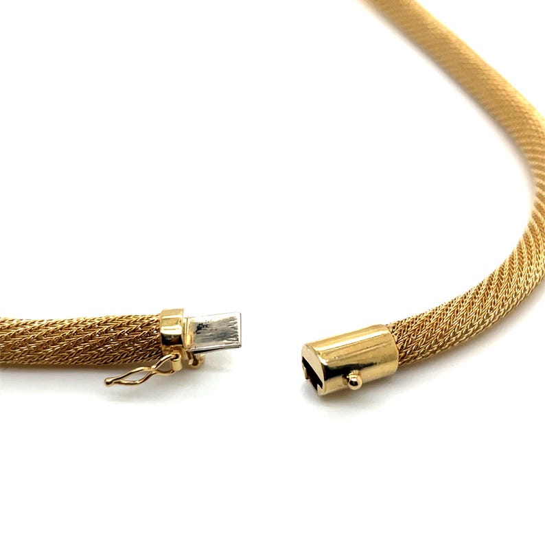 May include: A gold chain necklace with a woven mesh design. The necklace is open and the clasp is visible.