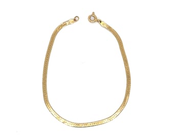 Pode incluir: Um bracelete de corrente de ouro com um design de corrente de cobra.