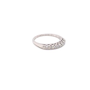 May include: A silver band ring with a row of small diamonds set in a delicate, openwork design.