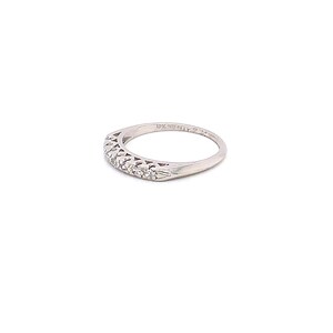 May include: A delicate silver band with a filigree design and small diamonds set in the band. The band is marked "14K GOLD PLAT."