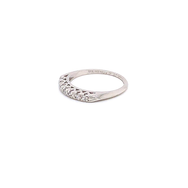 May include: A delicate silver band with a filigree design and small diamonds set in the band. The band is marked "14K GOLD PLAT."