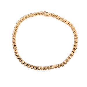 May include: A gold chain necklace with a delicate, intricate design. The chain is made of small, linked squares.
