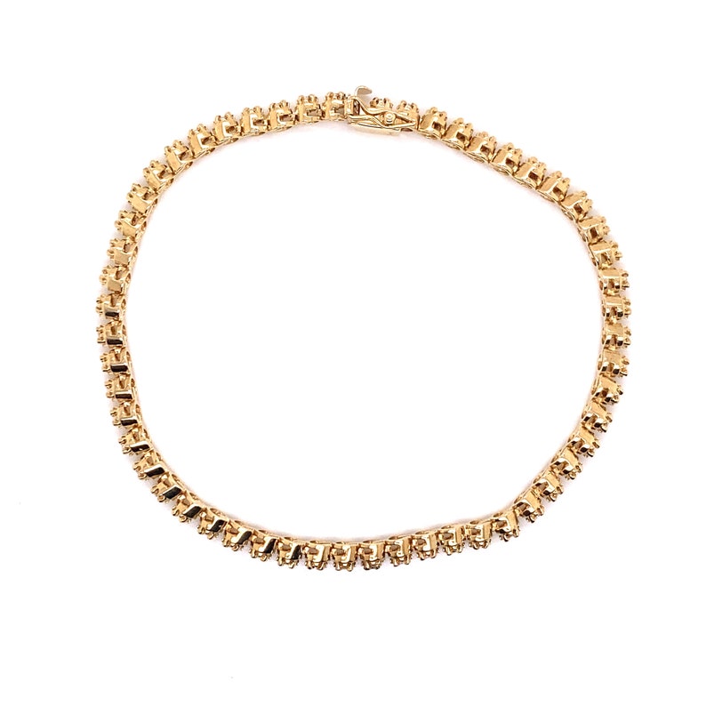May include: A gold chain necklace with a delicate, intricate design. The chain is made of small, linked squares.