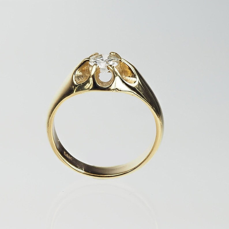 May include: A gold ring featuring a clear gemstone set in an open design.