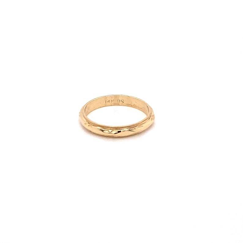 May include: A simple gold band ring with a textured surface. The ring is marked "14K 9S" on the inside.