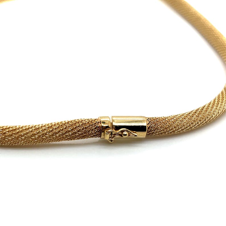 May include: A gold chain necklace with a woven mesh design and a secure clasp.