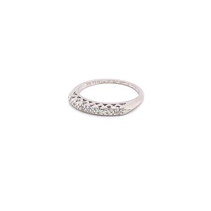 May include: A silver band ring with a row of small diamonds set in a curved design.
