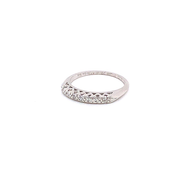 May include: A silver band ring with a row of small diamonds set in a curved design.