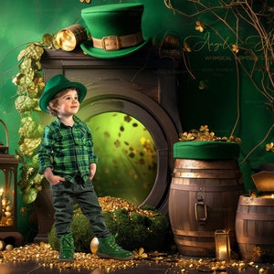 May include: A young boy wearing a green plaid shirt and a green hat with a gold buckle stands in front of a green backdrop. He is holding a gold coin in his hand. There are two wooden barrels with gold coins on top of them. The barrels are decorated with green fabric. There is a lantern on the left side of the image. The background is decorated with green leaves and gold coins.