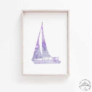 Puede incluir: Una impresión de silueta de velero en morado y blanco con un patrón de mapa vintage. La impresión está enmarcada en un marco de madera claro.