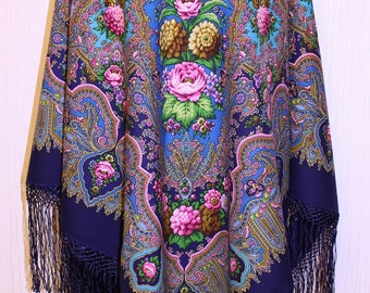 May include: A blue and gold patterned shawl with a floral design and fringe. The shawl is made of a soft, lightweight fabric and is perfect for adding a touch of elegance to any outfit.