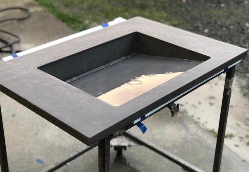 Puede incluir: Una encimera de hormig&oacute;n gris oscuro con un corte rectangular para un fregadero. El fregadero est&aacute; parcialmente lleno de una sustancia marr&oacute;n claro.