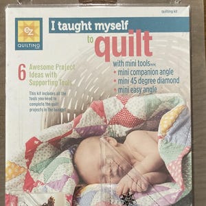 May include: A quilting kit in a clear plastic package. The package features the text "I taught myself to quilt" and includes tools for quilting. The image shows a baby wrapped in a colorful quilt.