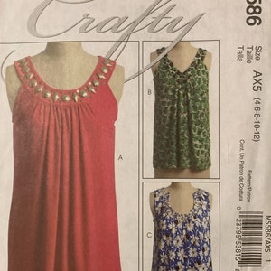 May include: McCall's Crafty sewing pattern M5586 featuring three sleeveless top designs. One top is red with jewel embellishments, another is green with a pattern, and the third is blue with a floral print.
