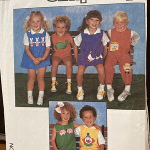 May include: A Simplicity sewing pattern envelope, number 8510, size N (4+5+6). The cover features photographs of children wearing various outfits, including a blue bunny dress, a green dinosaur romper, a purple goose dress, and a yellow clown romper.