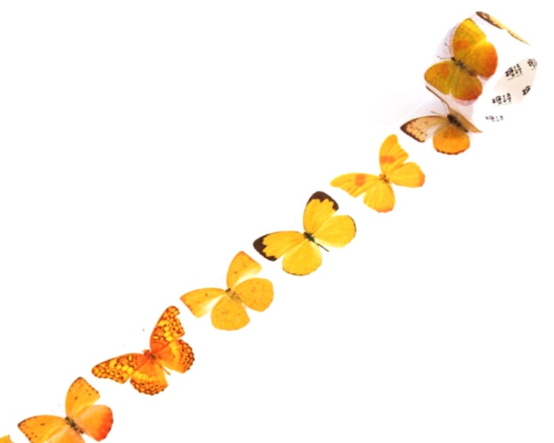 May include: A roll of washi tape with a repeating pattern of yellow butterflies. The tape is white with a black and white pattern on the back.