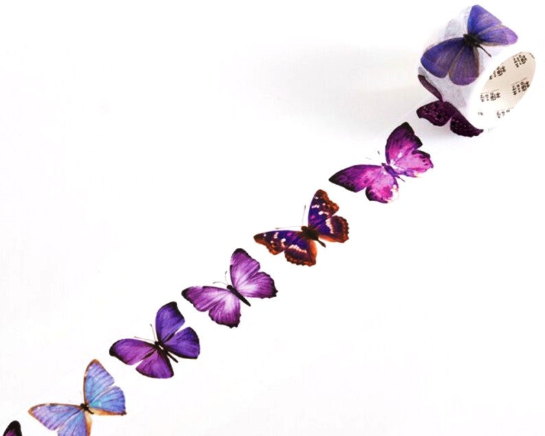 May include: A roll of washi tape with a repeating pattern of purple, pink, and blue butterflies. The tape is on a white background.