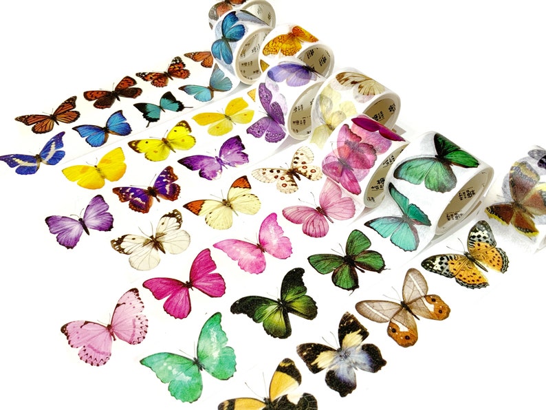 May include: Assortment of colorful washi tapes featuring butterfly designs. Each tape has a different butterfly pattern and color, including pink, blue, green, yellow, and purple.