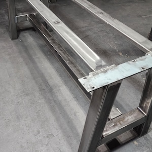 May include: A metal table base with a rectangular top and four legs. The base is made of heavy-duty steel and has a welded construction.