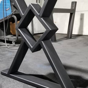 May include: Black metal table base with a geometric design. The base is made of thick, sturdy metal and has a black powder coat finish.
