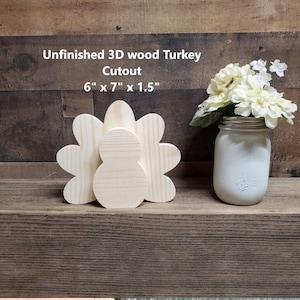 Puede incluir: Corte de pavo de madera 3D sin terminar, 15,2 cm x 17,8 cm x 3,8 cm, hecho de madera natural. El pavo está de pie sobre una superficie de madera.