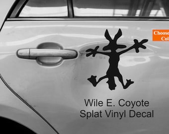 May include: A black and white vinyl decal of Wile E. Coyote splattered on a car door. The decal is a silhouette of Wile E. Coyote with his arms outstretched. The text "Wile E. Coyote Splat Vinyl Decal" is below the decal. A small orange arrow with the text "Choose Your Color" is in the upper right corner of the image.
