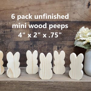 May include: Six unfinished wooden mini peep figures, each measuring 4 inches by 2 inches by 0.75 inches. The figures are arranged in a row on a wooden surface.