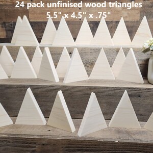 May include: 24 pack of unfinished wood triangles, each measuring 5.5 inches by 4.5 inches by 0.75 inches. The triangles are arranged in three rows on a wooden surface.