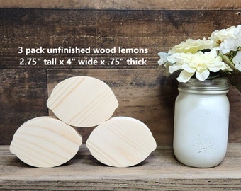 May include: Three unfinished wooden lemons, each measuring 2.75 inches tall, 4 inches wide, and 0.75 inches thick. The lemons are arranged in a triangular shape on a wooden surface.